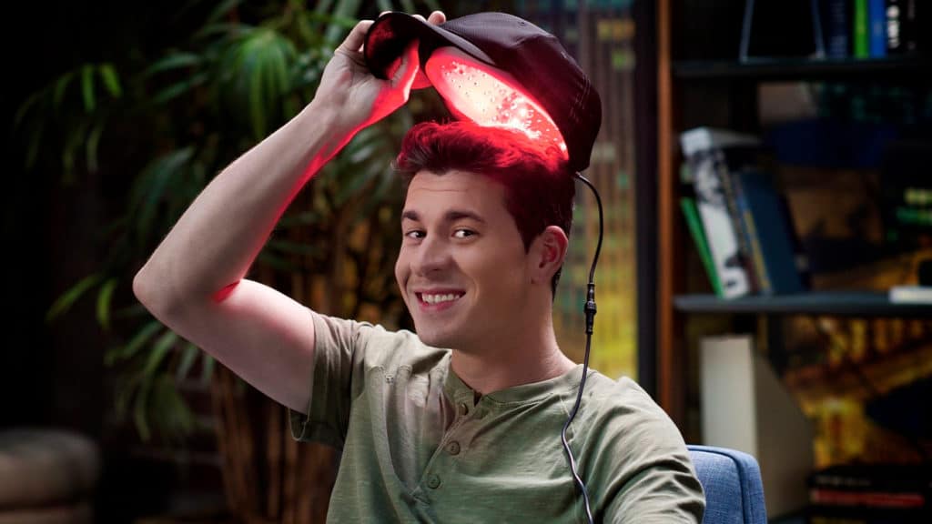 man with low level laser therapy cap for hair growth